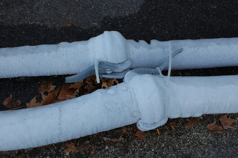 Image of frozen pipes leading into a home.